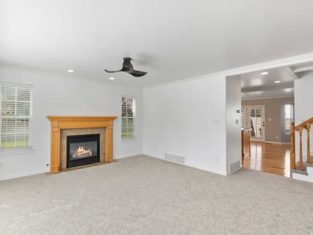 Living area featuring a gas fireplace with a wood-finish mantel, recessed lighting, and a ceiling fan