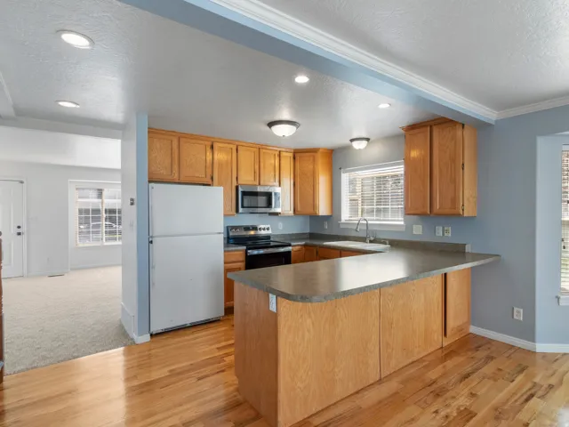 Kitchen featuring wood cabinetry, stainless steel appliances, a breakfast bar, and wood-finish flooring