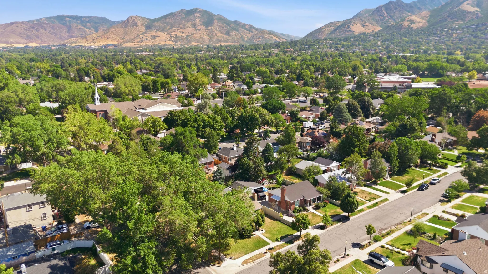 Expansive residential area with mature trees and mountain backdrops