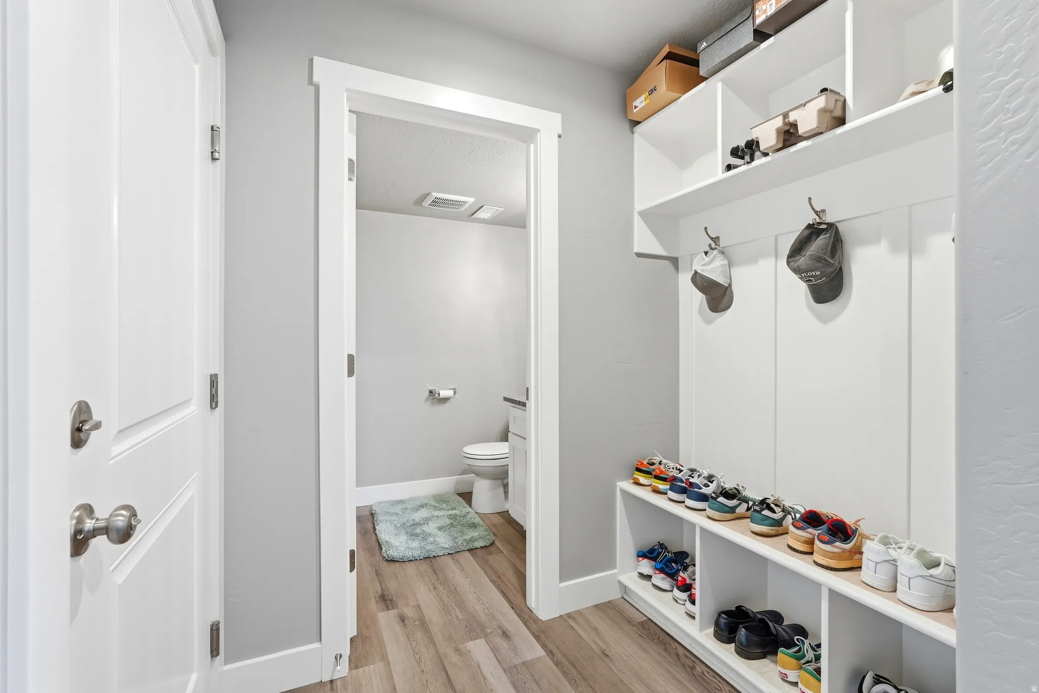 Entryway mudroom featuring built-in shelving, coat hooks, and shoe storage