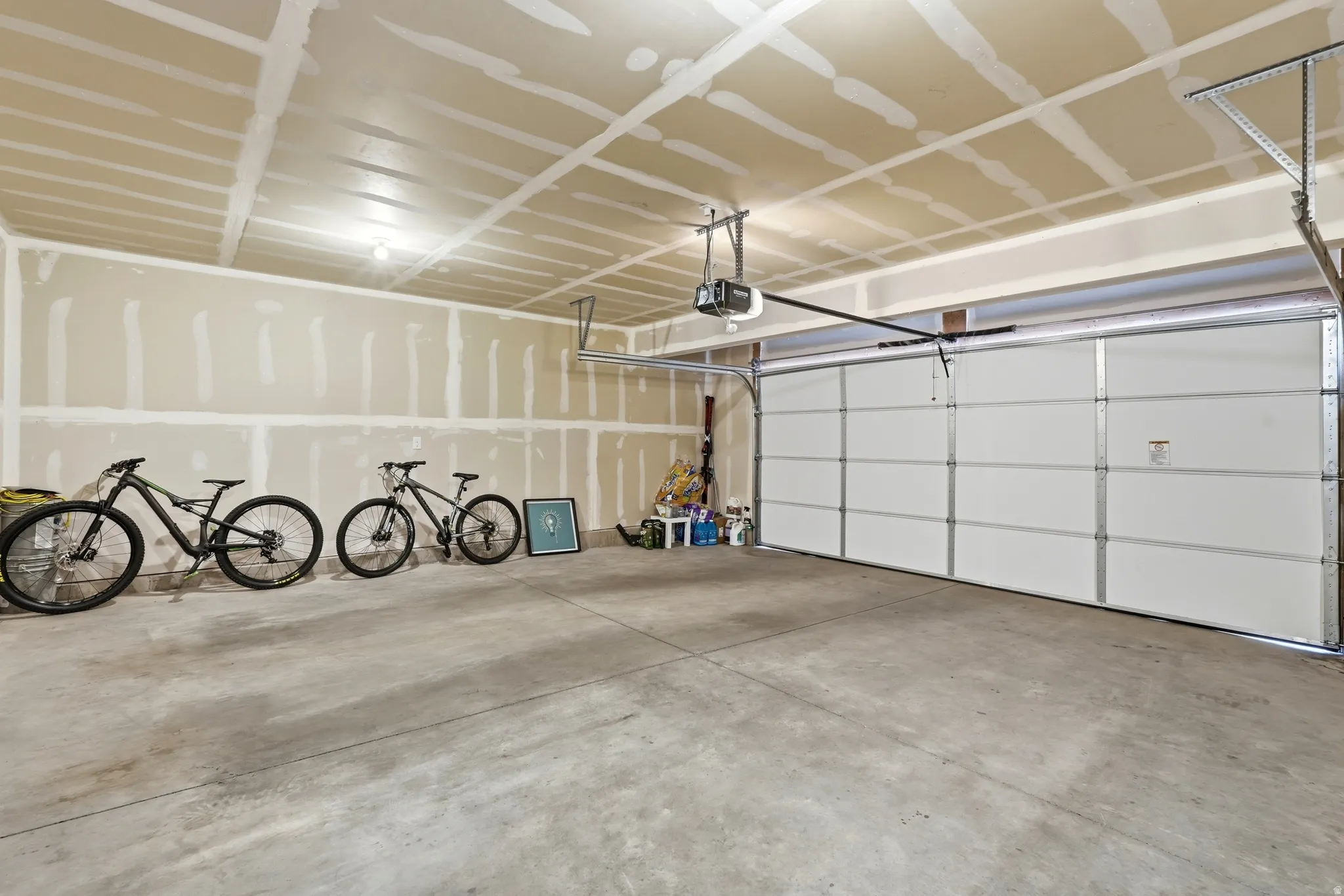 Spacious garage featuring a concrete floor, an overhead garage door, and an automatic garage door opener