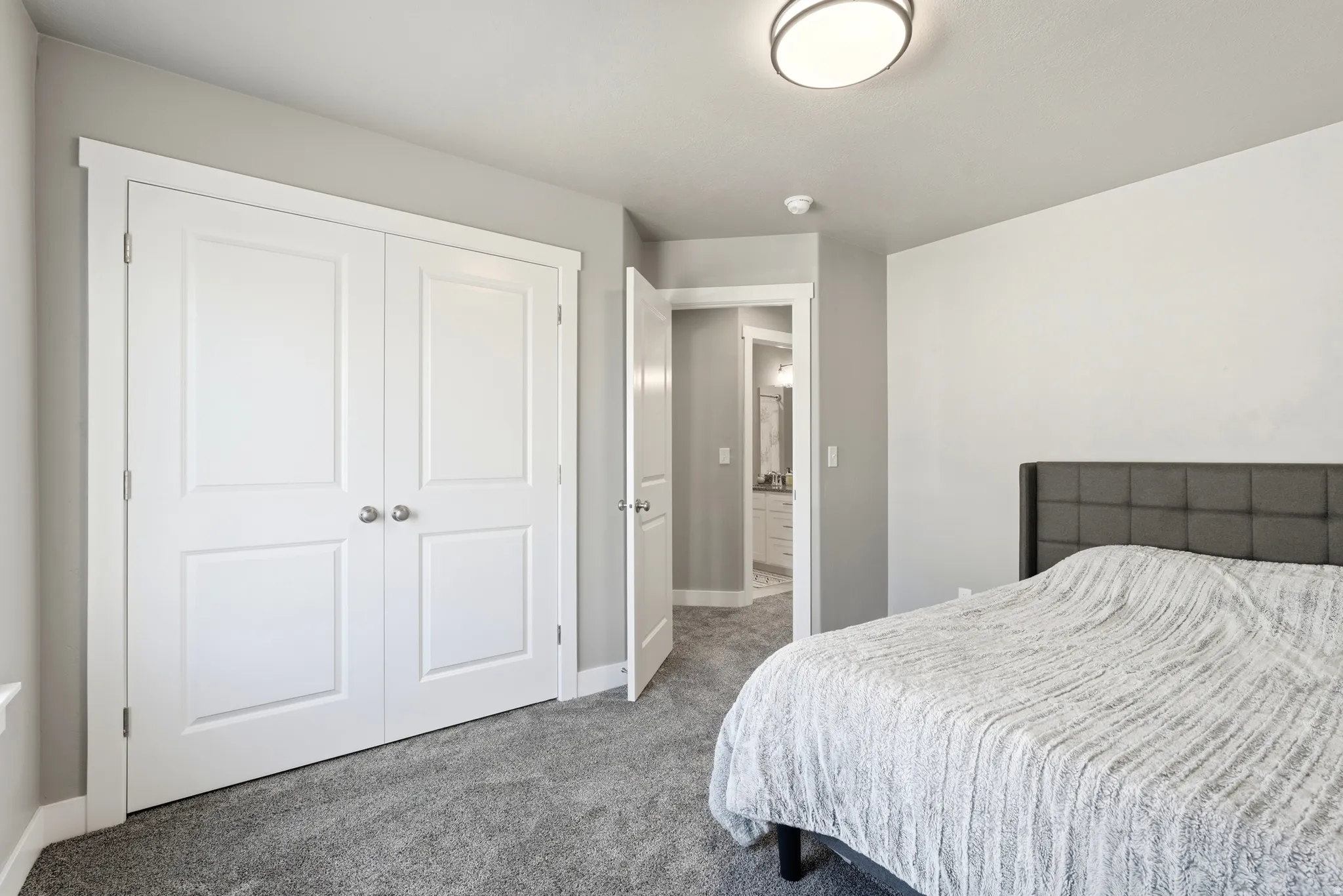 Bedroom with gray carpeting and a contemporary ceiling light fixture