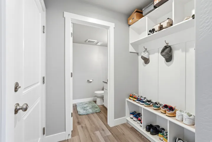 Entryway mudroom featuring built-in shelving, coat hooks, and shoe storage