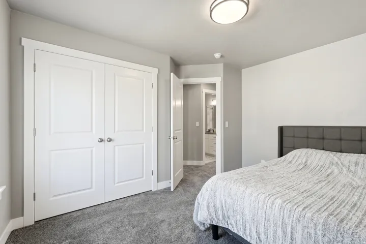 Bedroom with gray carpeting and a contemporary ceiling light fixture