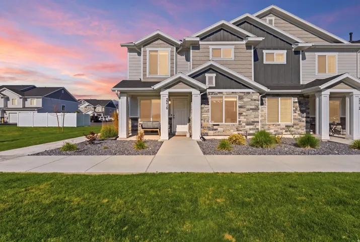 Contemporary townhome exterior featuring multi-toned siding and stone accents