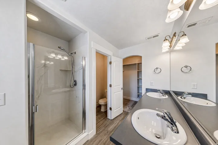 Bathroom featuring a dual-sink vanity with a dark countertop and chrome fixtures