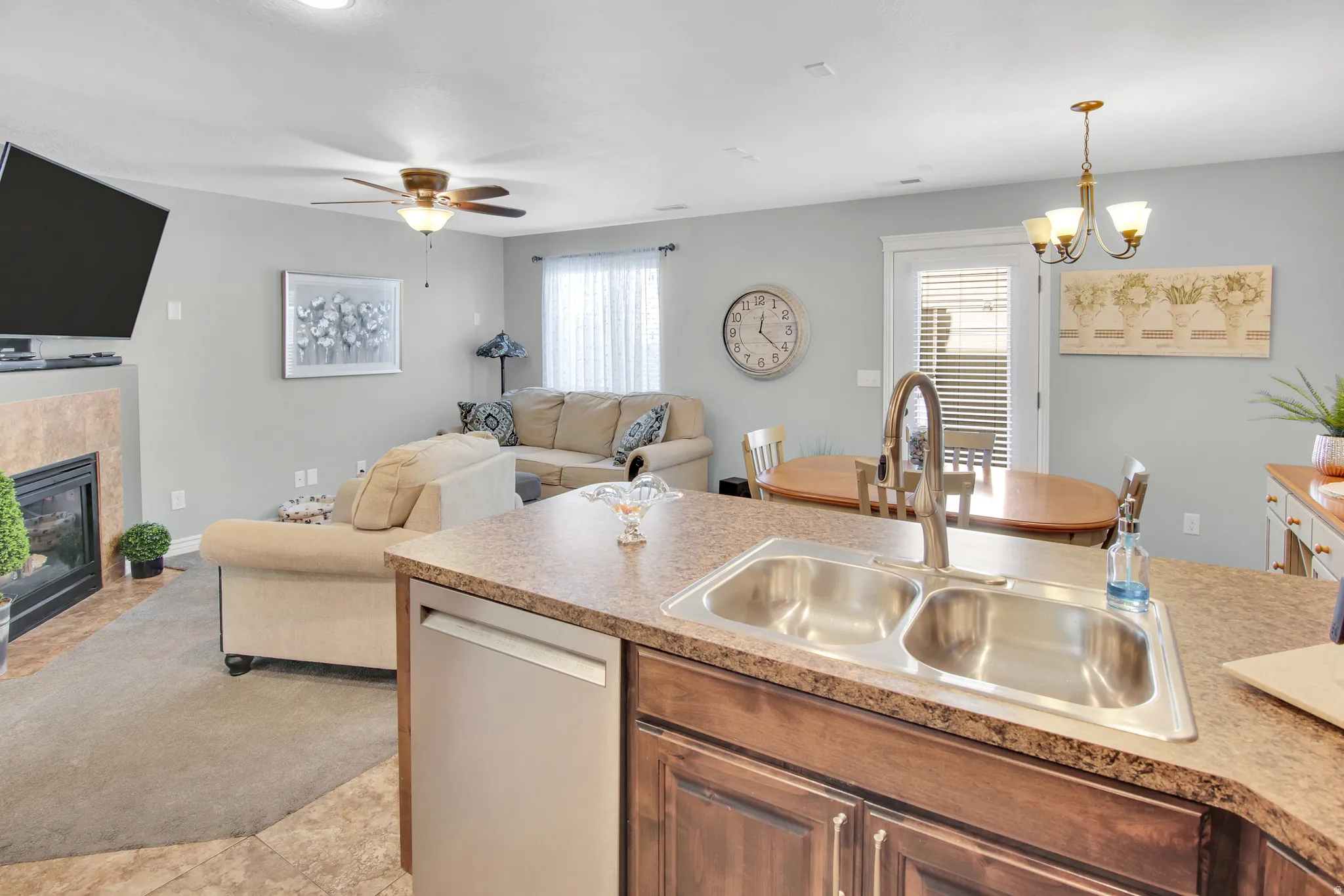 Kitchen island featuring a double basin stainless steel sink, a high-arc faucet, and a dishwasher