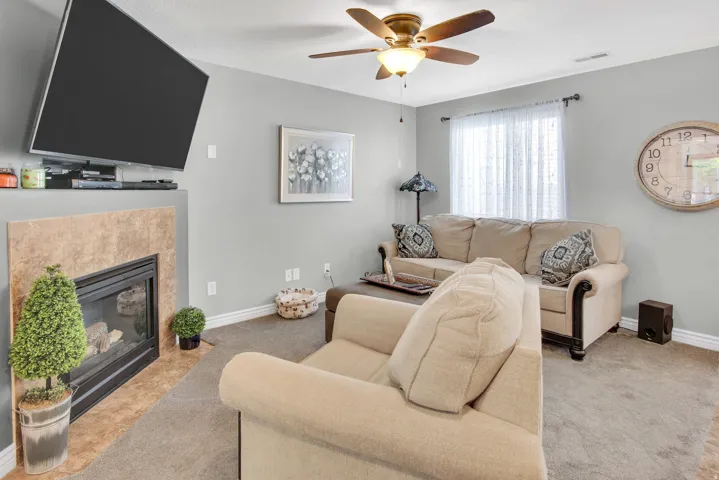 Living area featuring a floor-to-ceiling fireplace with a tile surround and mantel