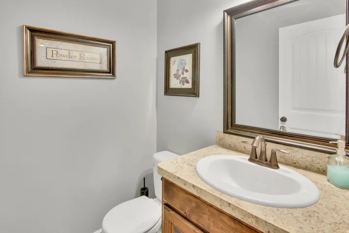 Vanity featuring an oval sink, bronze-tone faucet, and a stone-finish countertop