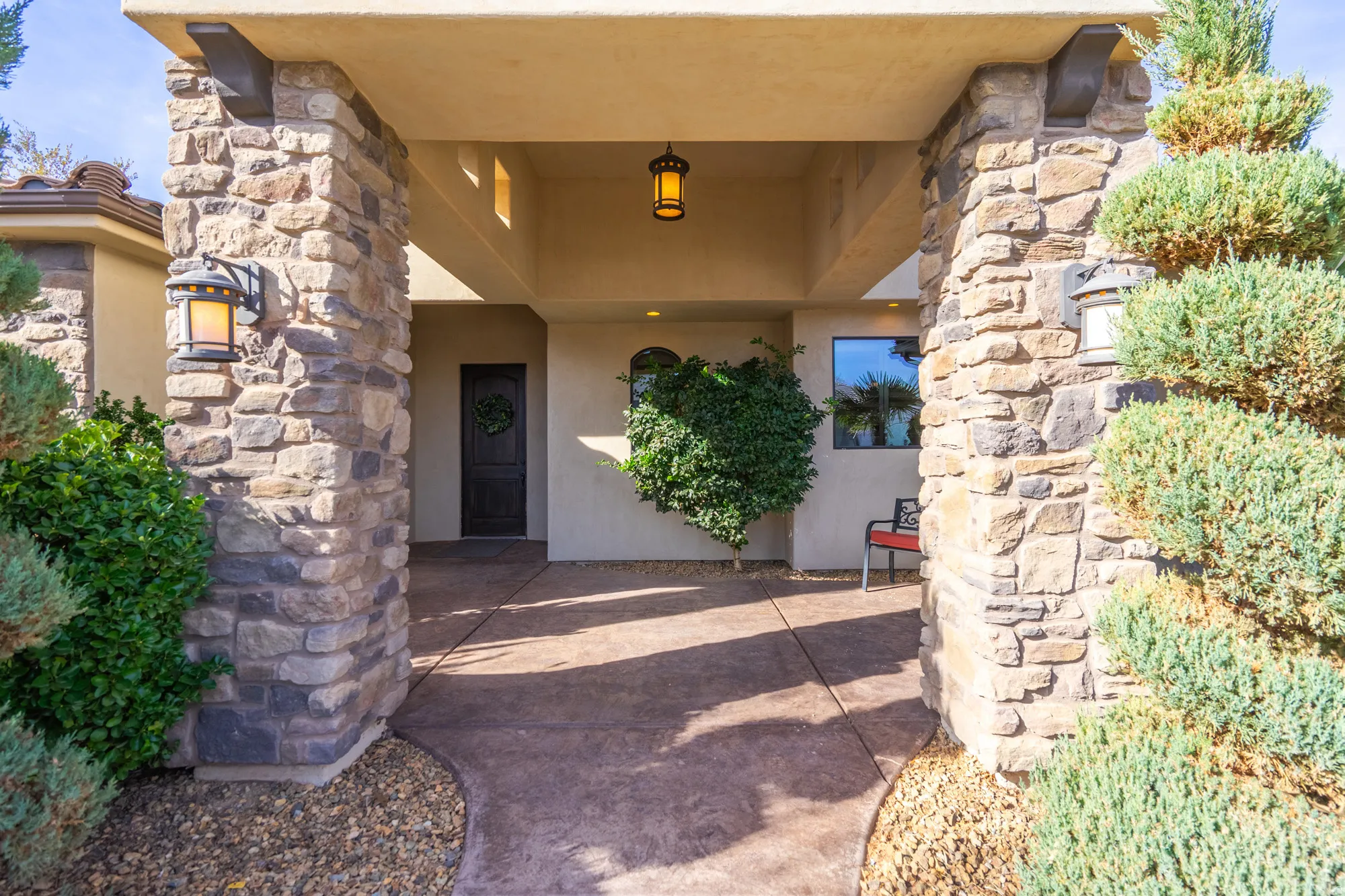 Stone-clad columns framing an inviting entryway with a dark wood-finish front door