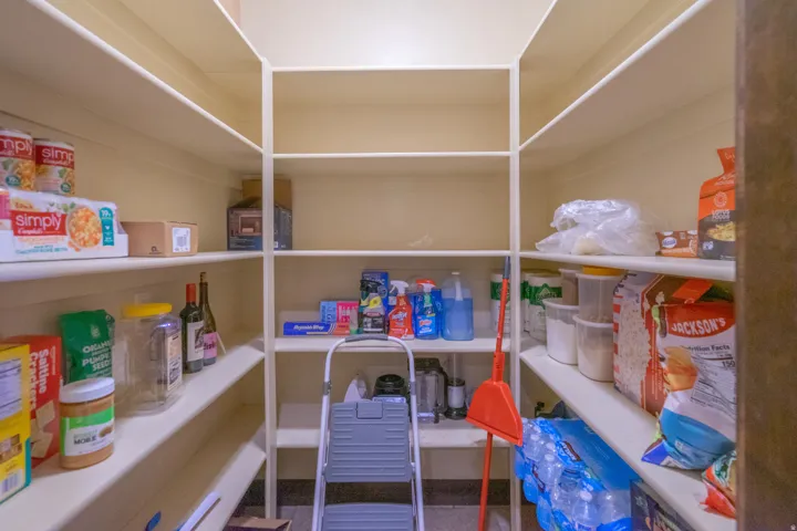Spacious walk-in pantry with extensive built-in shelving, providing ample storage capacity
