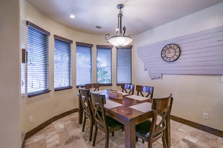 Dining area with curved wall of windows featuring wood blinds and trim