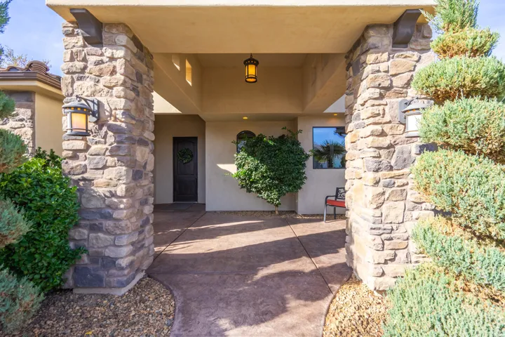 Stone-clad columns framing an inviting entryway with a dark wood-finish front door