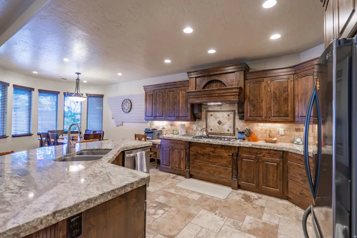 Spacious kitchen featuring rich wood cabinetry, stone countertops, and a full suite of stainless steel appliances