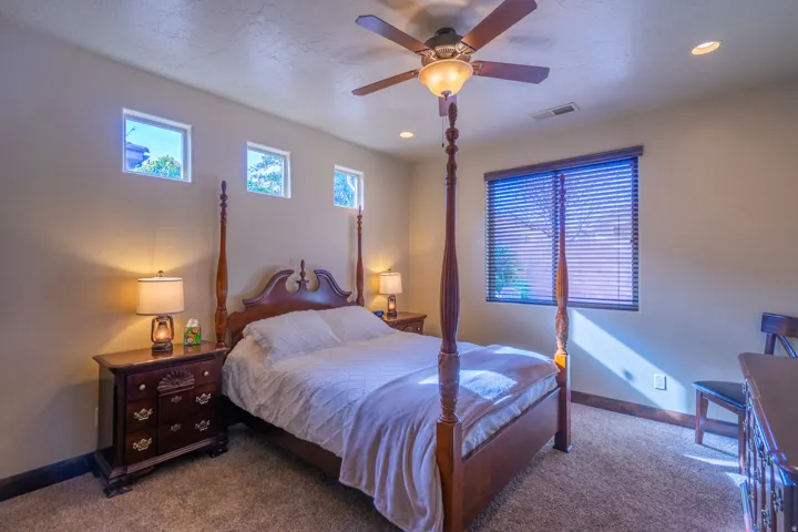 Carpeted room featuring a ceiling fan with integrated lighting, recessed lighting, and multiple windows with blinds