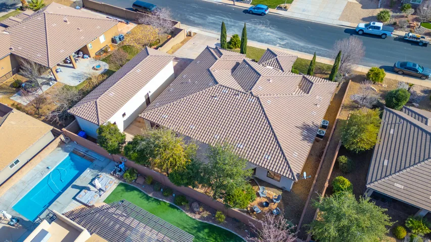 Expansive property featuring a multi-gabled tiled roof, mature landscaping, and a long driveway