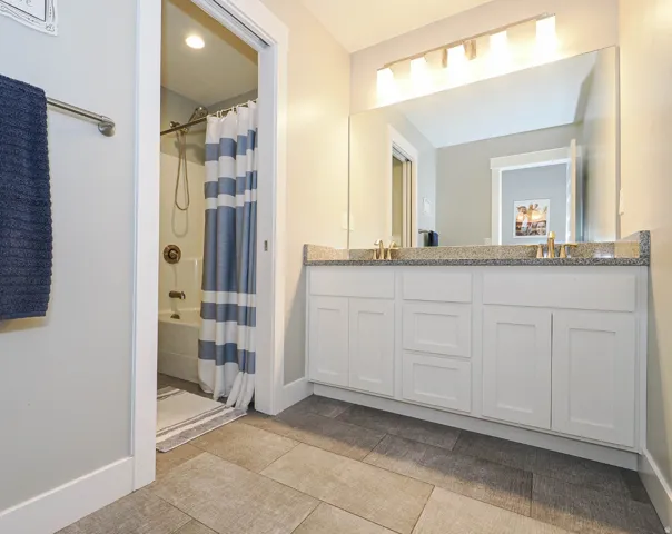 Dual vanity bathroom with separate tub and toilet area