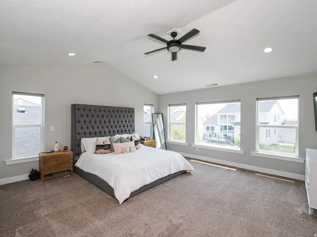 Large primary bedroom with vaulted ceiling and lots of light