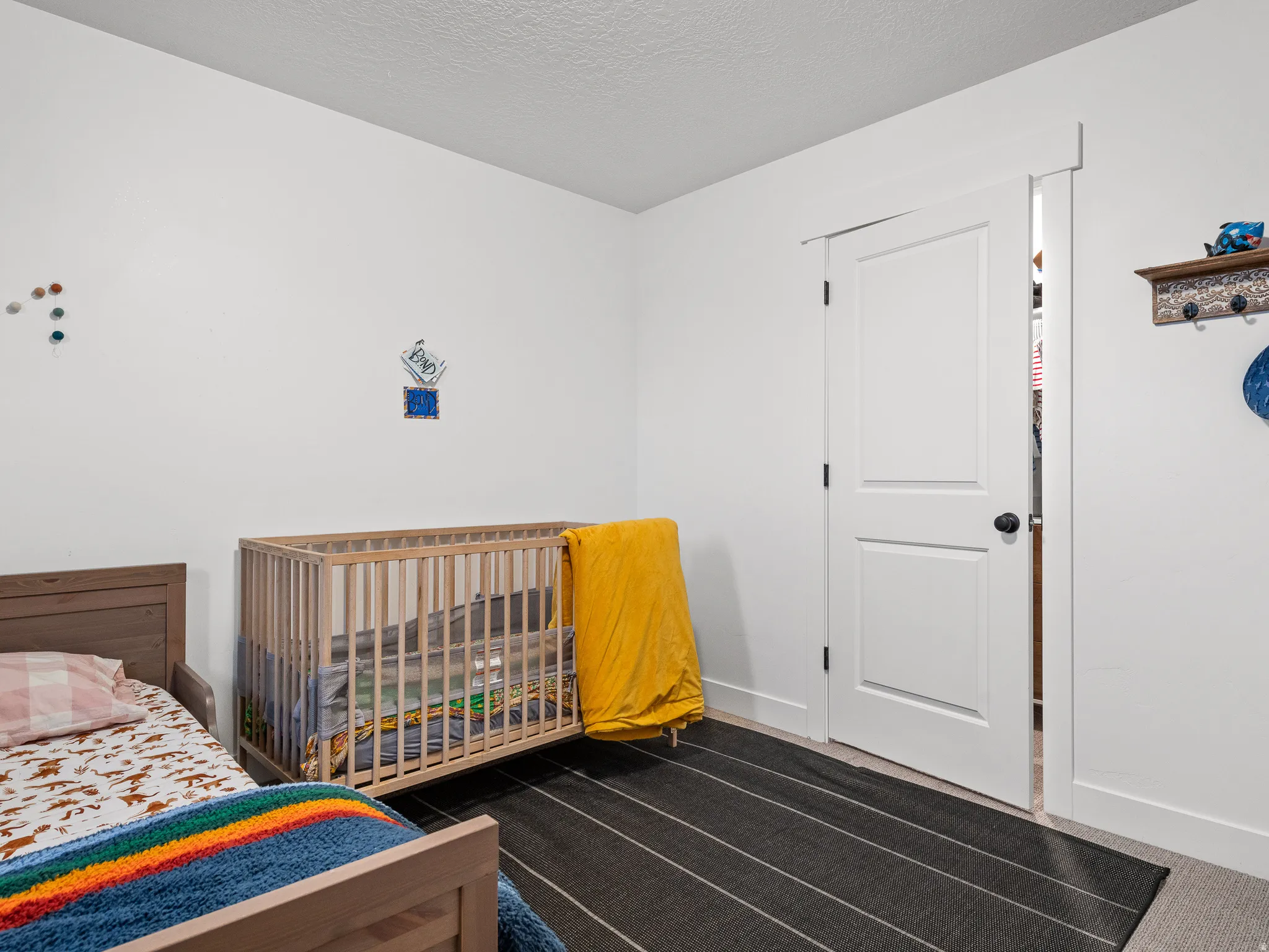 Bedroom featuring light gray carpeting, crisp white walls, and a white two-panel door