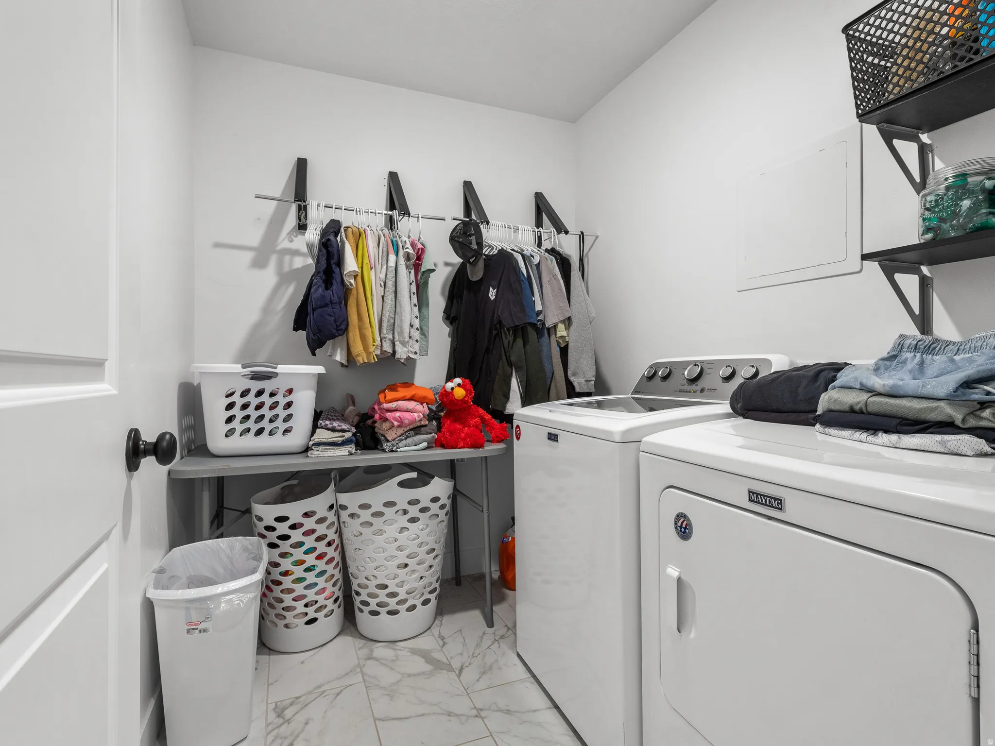 Dedicated laundry space featuring a white top-load washing machine and front-load dryer