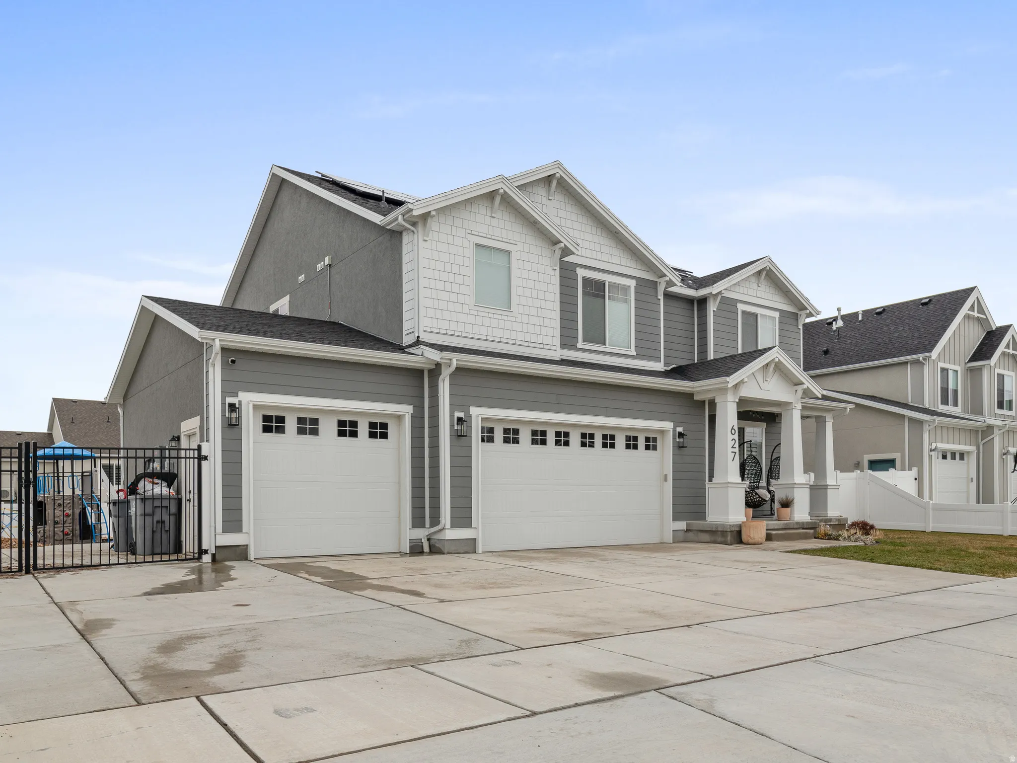 Contemporary two-story residence with a gray siding exterior and white trim accents