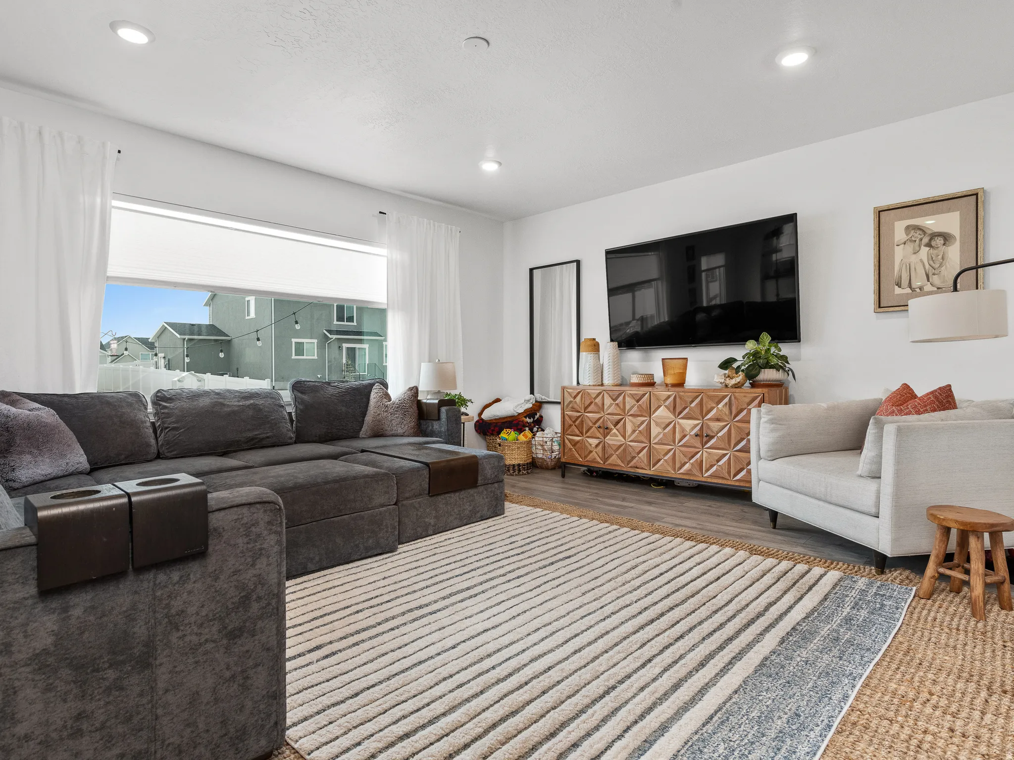 Spacious living area featuring neutral walls, recessed lighting, and wood-finish flooring