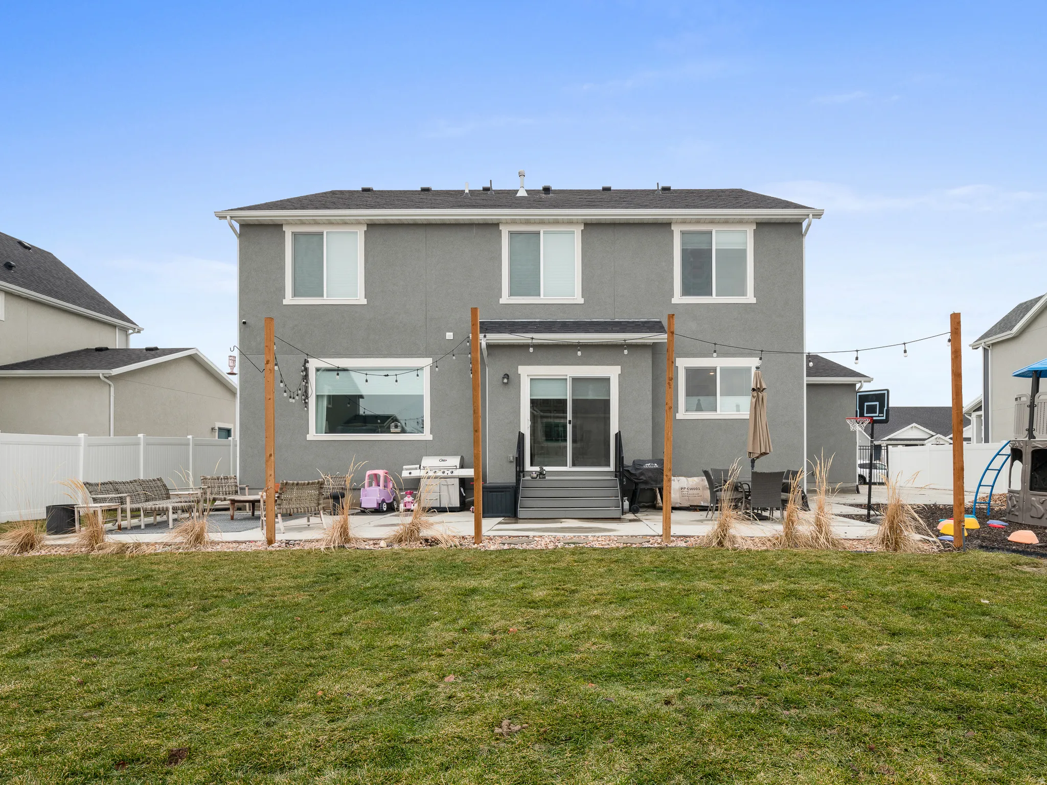 Two-story stucco exterior with white trim windows and a glass sliding door