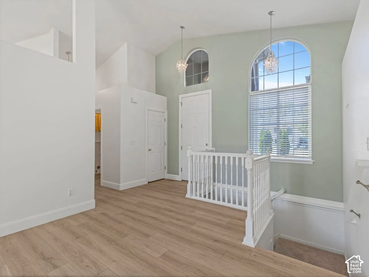 Entryway featuring wood-finish flooring, vaulted ceilings, and arched windows