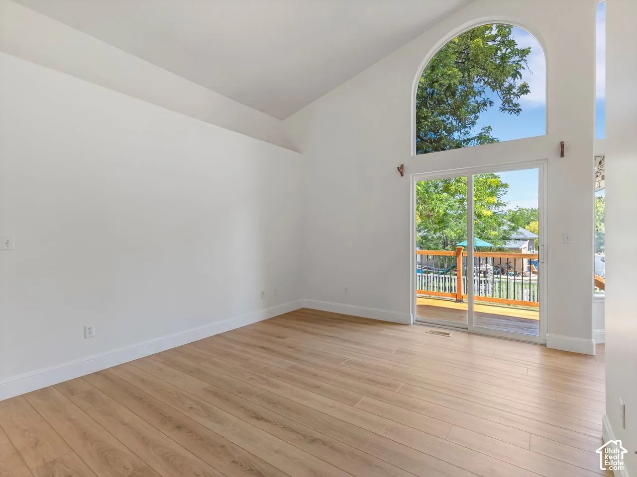 Vaulted ceilings enhance this room featuring light wood-finish flooring