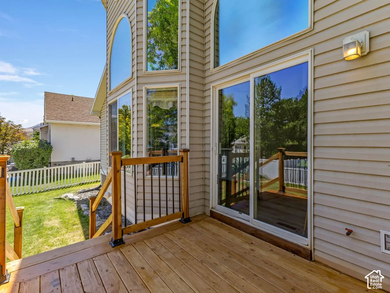 Outdoor wood deck with natural wood railings and black metal balusters