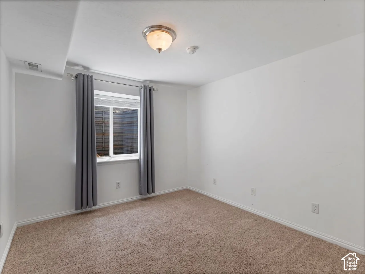 Carpeted room featuring white painted walls, white baseboards, and a single window