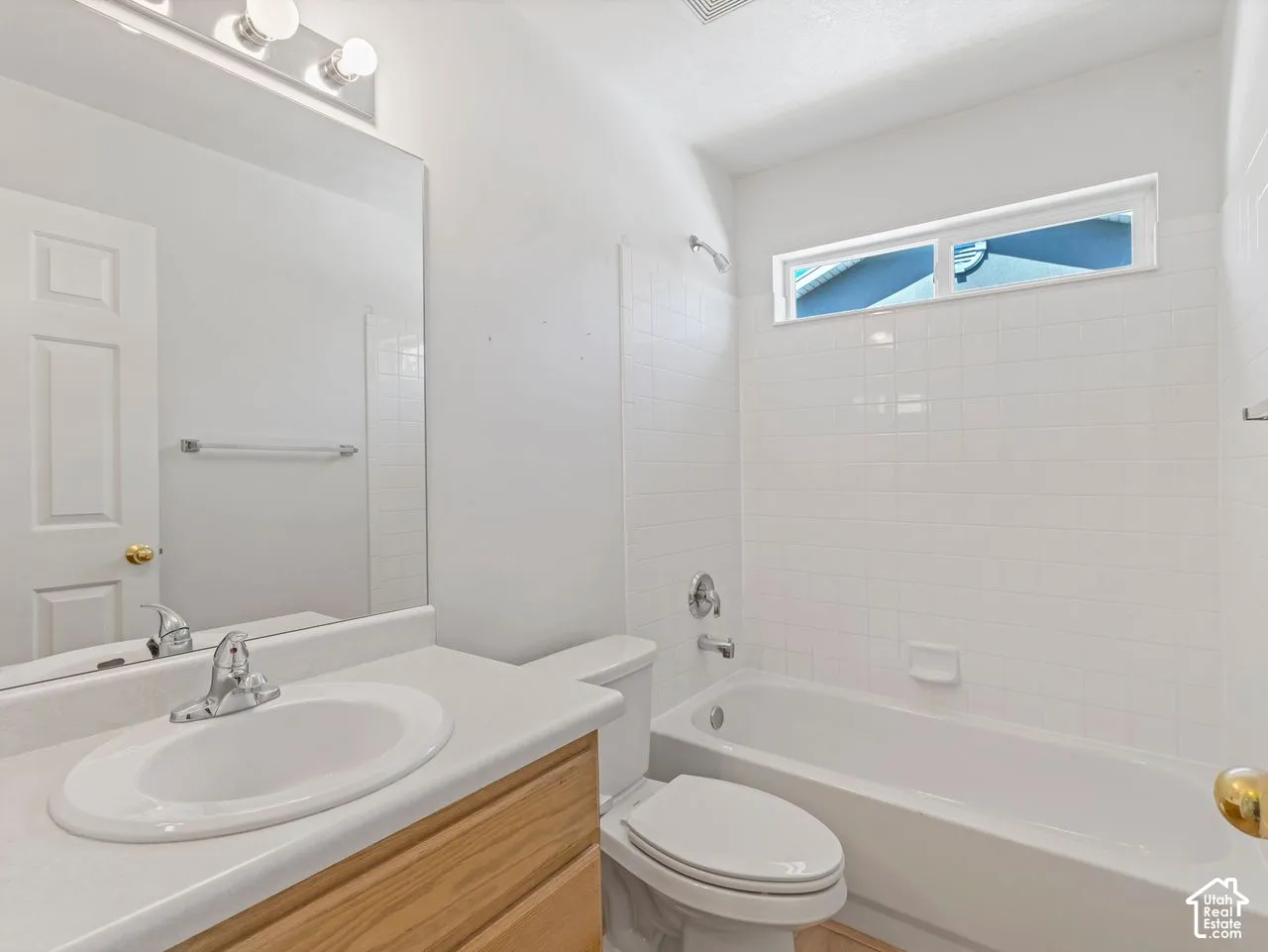 Full bathroom featuring a single vanity with an integrated sink, a large mirror, and overhead lighting
