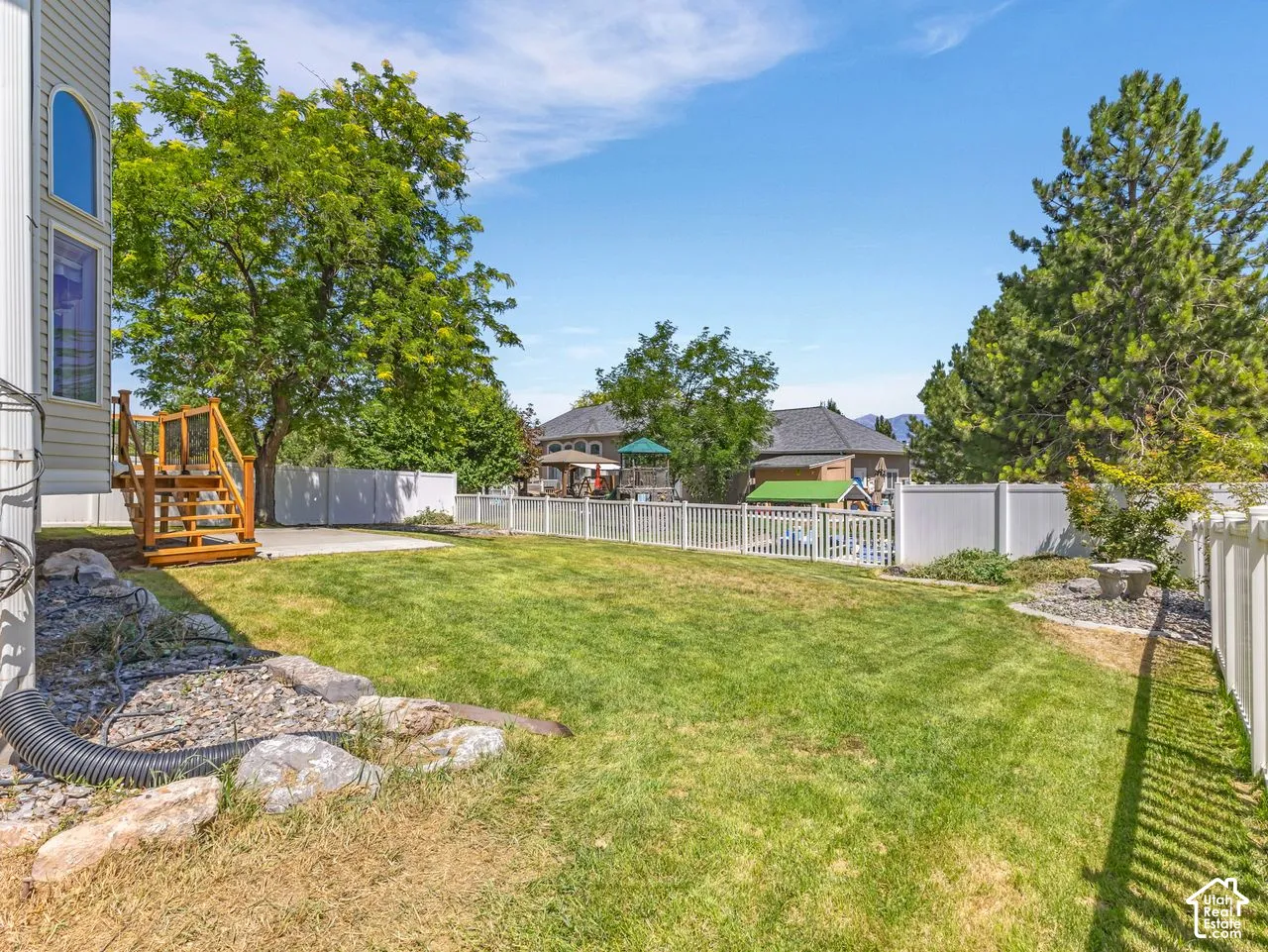 Expansive lawn area with a white vinyl fence