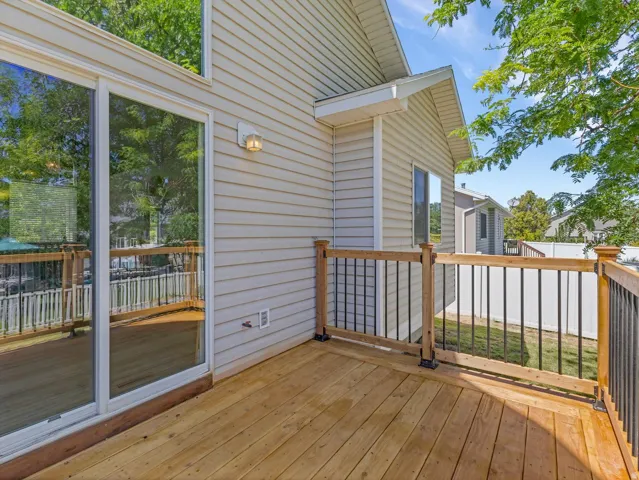 Expansive wood deck with black metal spindle railing and natural wood posts