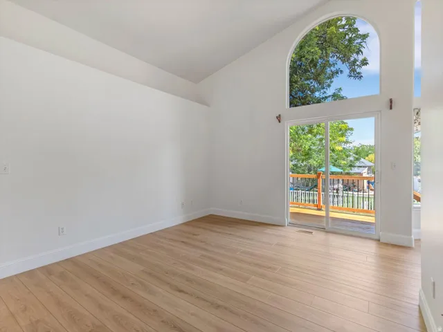 Vaulted ceilings enhance this room featuring light wood-finish flooring