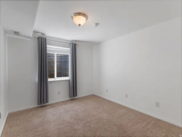 Carpeted room featuring white painted walls, white baseboards, and a single window