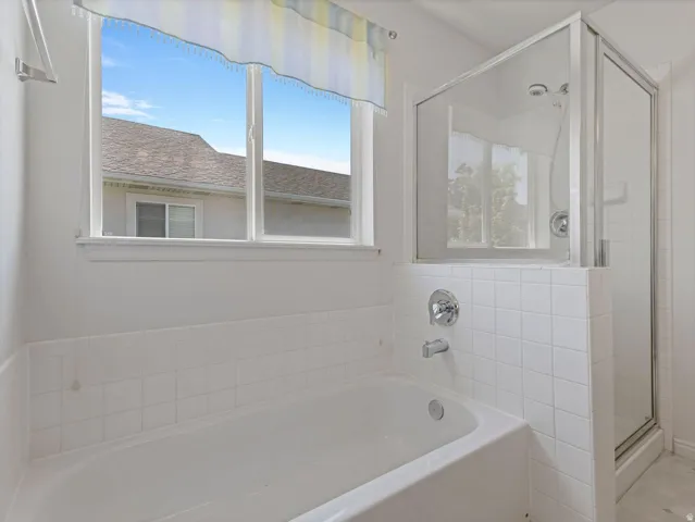 White ceramic subway tile surrounds a built-in bathtub with chrome fixtures