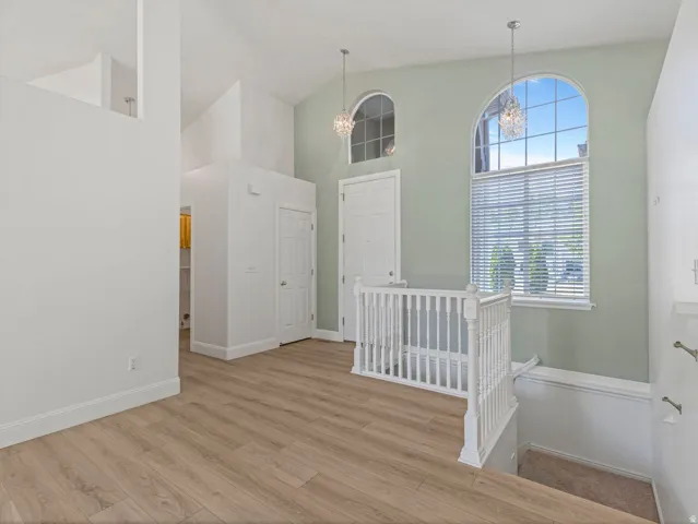 Entryway featuring wood-finish flooring, vaulted ceilings, and arched windows
