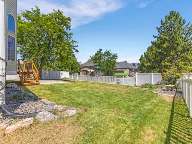 Expansive lawn area with a white vinyl fence