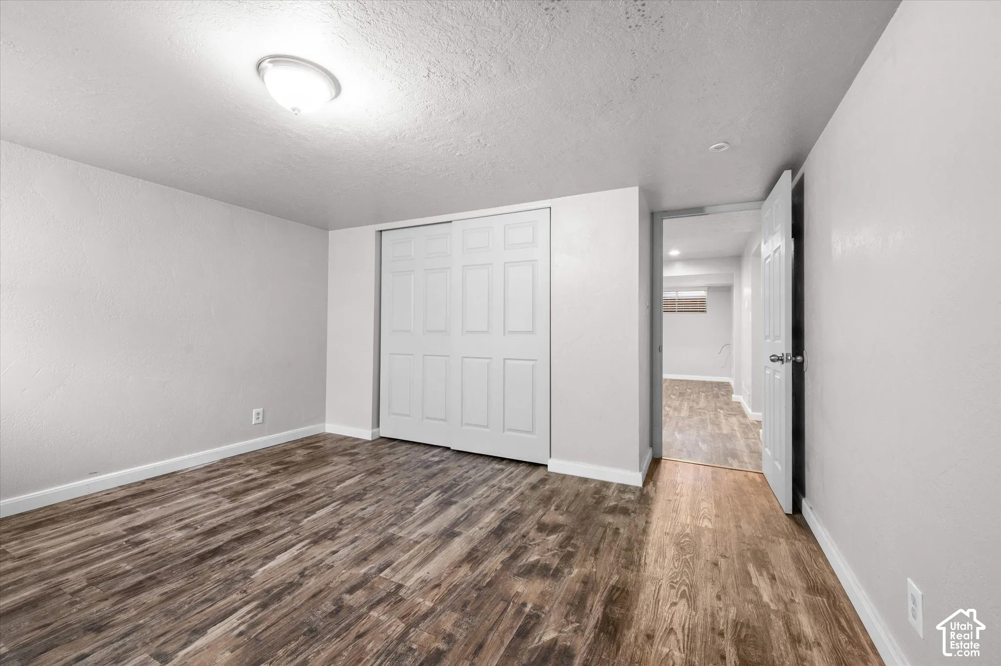 Wood-finish flooring, neutral wall tones, and overhead lighting