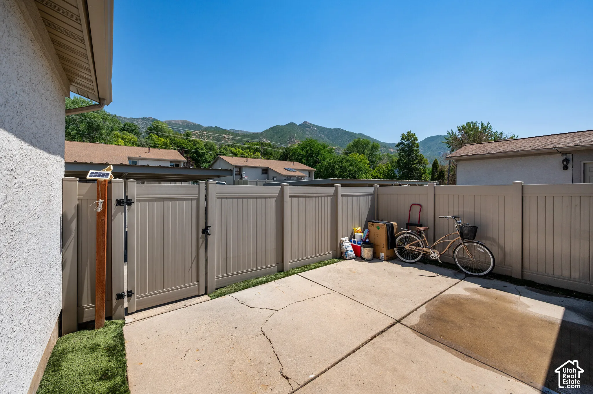 Concrete patio space with a privacy fence and a gated entry