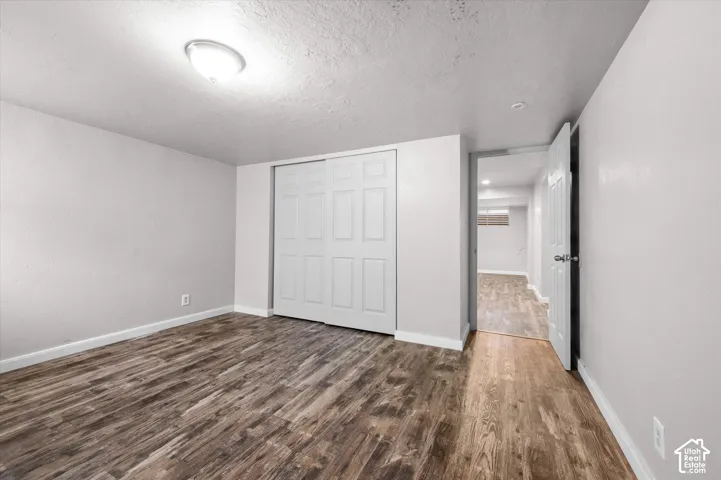 Wood-finish flooring, neutral wall tones, and overhead lighting