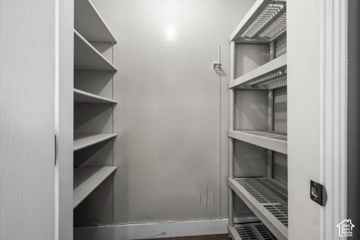 Spacious storage area featuring built-in shelving and freestanding storage units