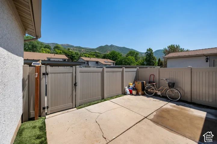 Concrete patio space with a privacy fence and a gated entry