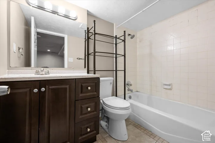 Vanity with dark wood-finish cabinetry, light-toned countertop, and chrome fixtures