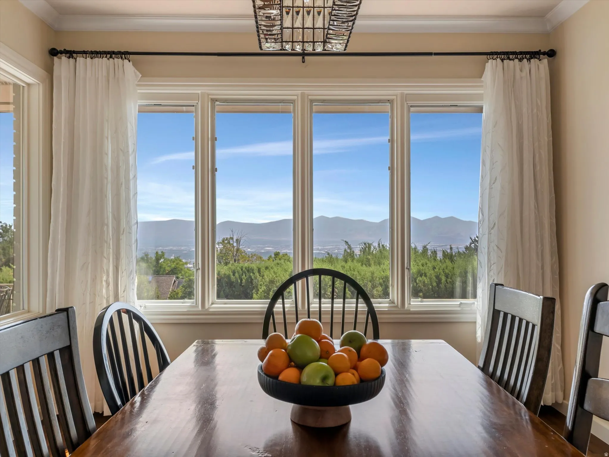 Expansive multi-pane window with mountain scenery and green foliage