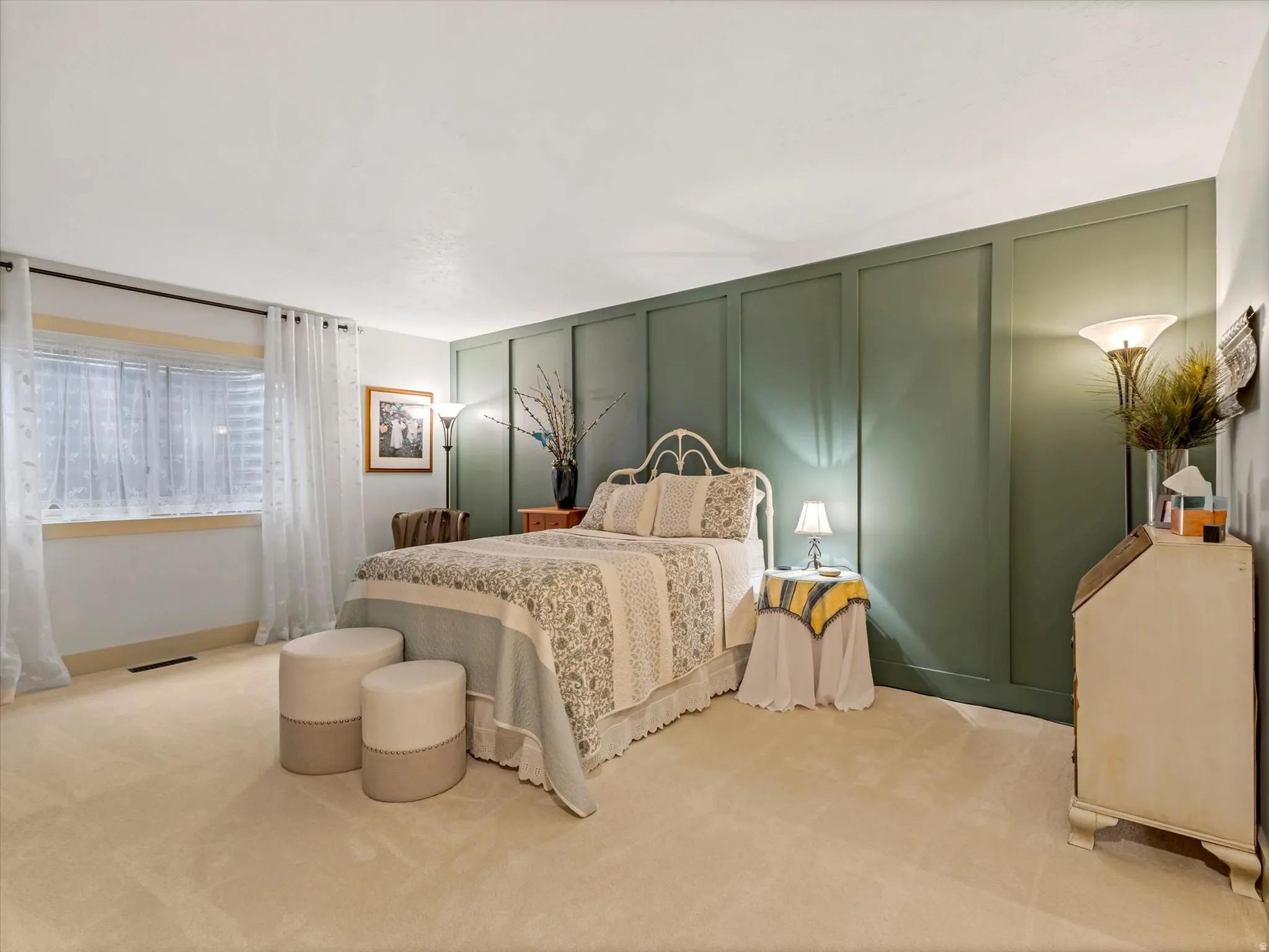 Bedroom featuring a panel accent wall, neutral carpeting, a large window with blinds, and white trim