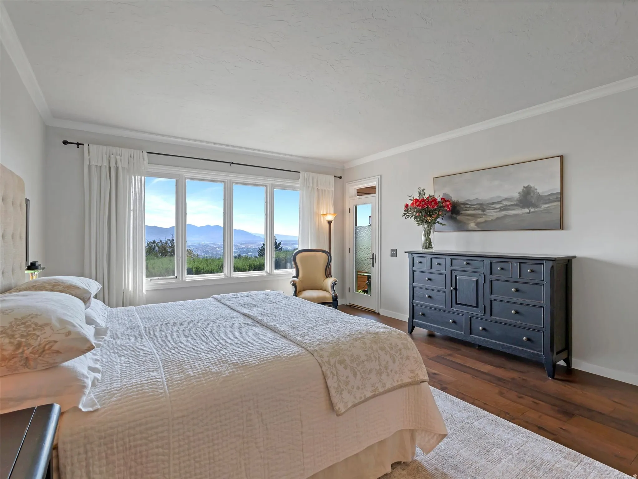 Wood-finish flooring with a multi-pane window featuring a distant mountain scenery