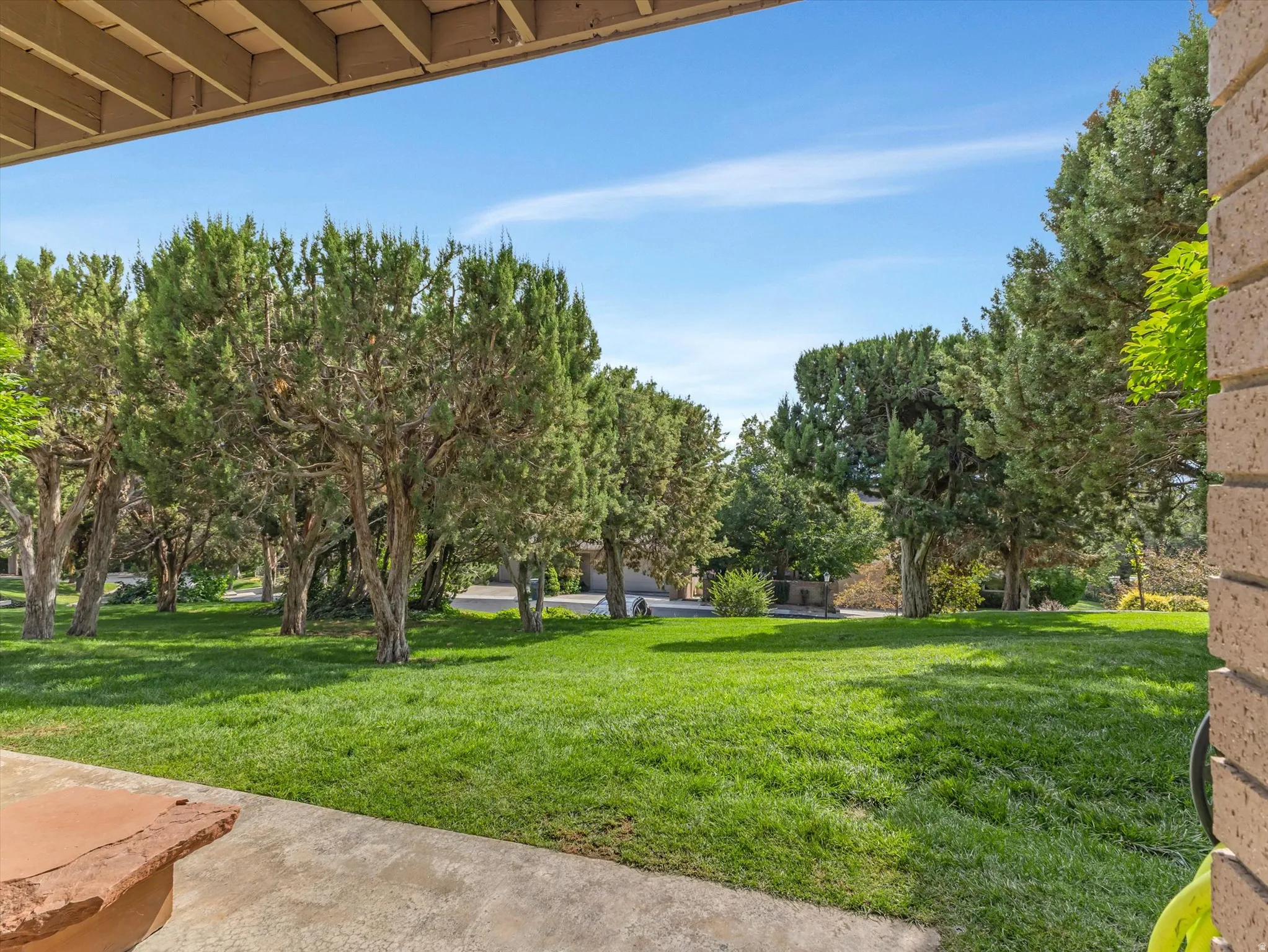 Expansive green lawn framed by mature trees, creating a private outdoor setting