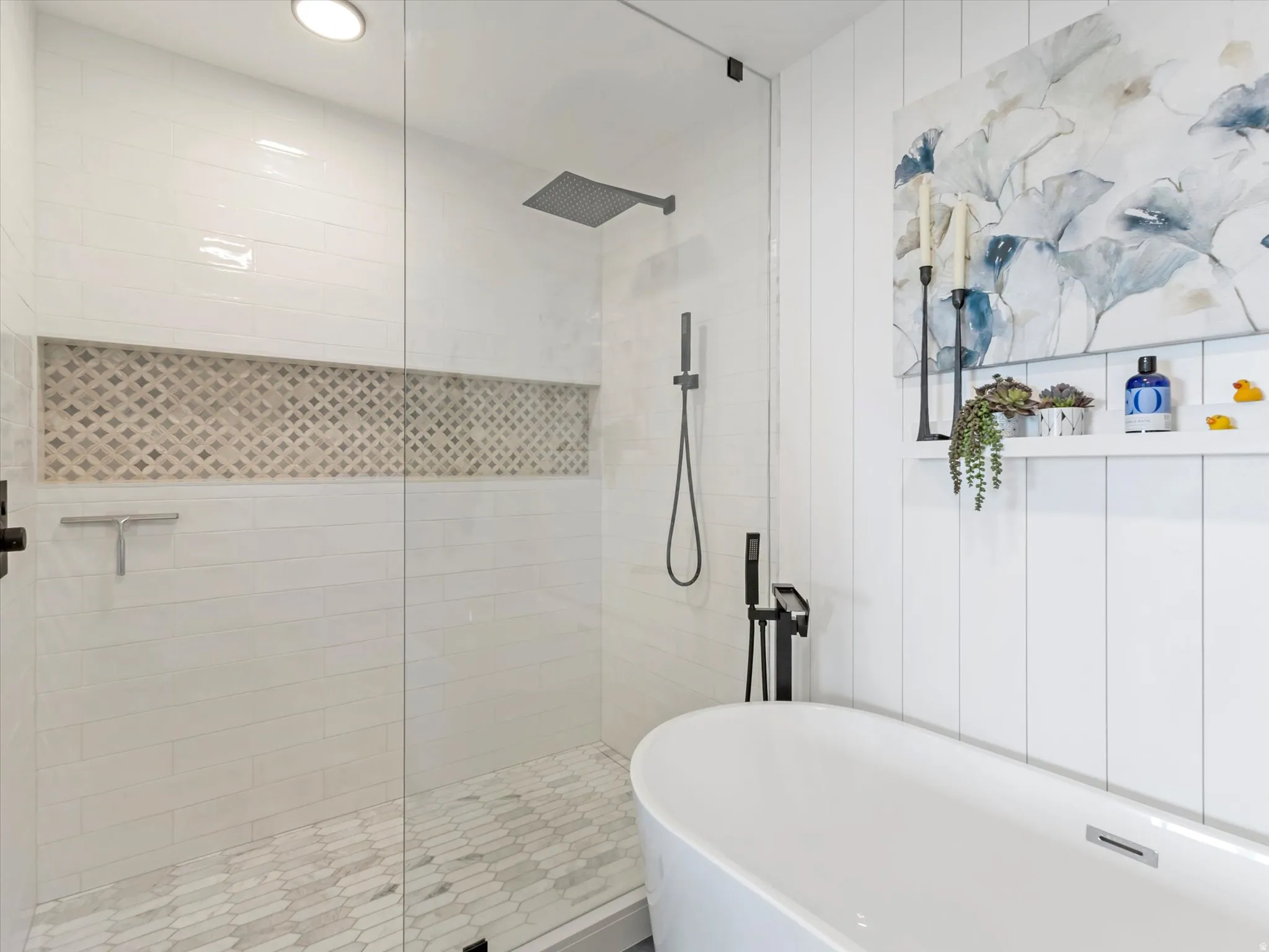 Contemporary bathroom featuring a frameless glass shower enclosure with a rain showerhead, a patterned tile shower niche, and matte black fixtures